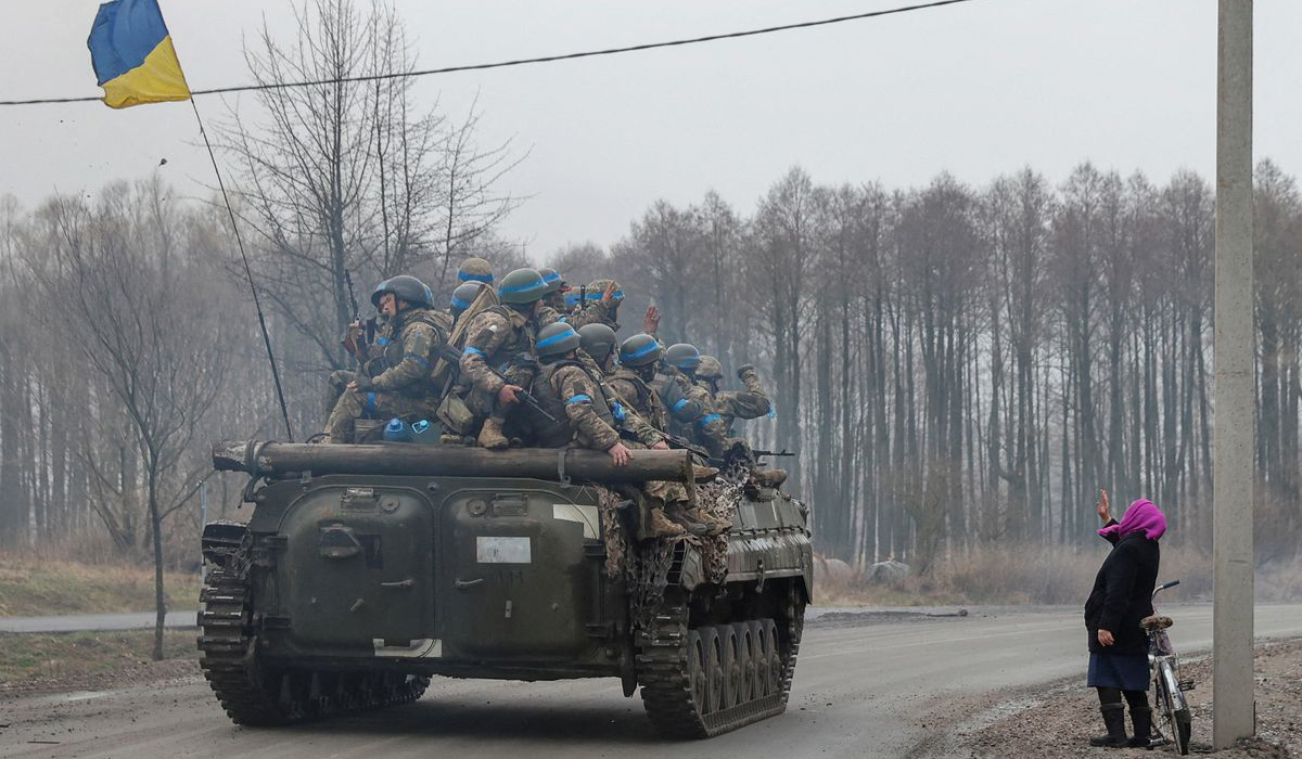 A local woman salutes Ukrainian service members